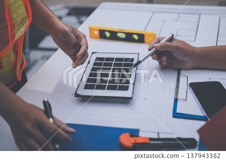engineer and an architect reviewing blueprints and construction plans together at a bustling construction site engineer and an architect reviewing blueprints and construction plans together at a bustling construction site 137943382