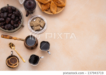 Oriental sweets and coffee on the table during Ramadan. Baklava and dates top view. Sweet food background copy space. Oriental sweets and coffee on the table during Ramadan. Baklava and dates top view. Sweet food background copy space. 137943719