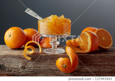 Orange jelly in a glass dessert bowl on an old wooden table. Orange jelly in a glass dessert bowl on an old wooden table. 137943841