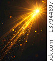 Golden Light Rays with Glittering Particle Stream on a Dark Background 137944897