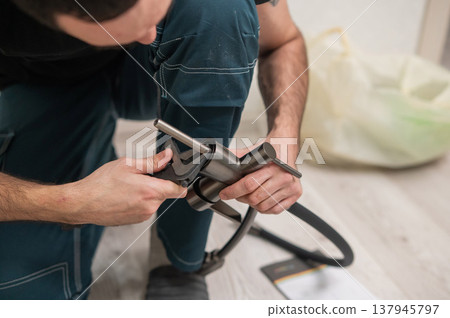 A plumber is replacing a faucet in the kitchen. A plumber is replacing a faucet in the kitchen. 137945797