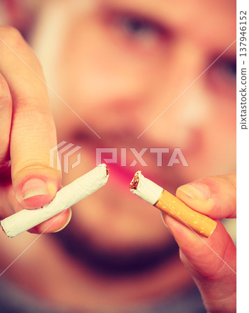 Young man is breaking a cigarette Young man is breaking a cigarette 137946152