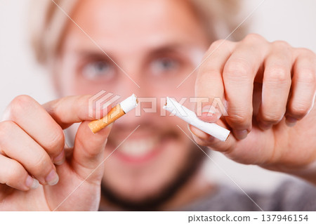 Smilling man is breaking a cigarette Smilling man is breaking a cigarette 137946154