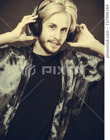 Blonde man singing in studio wearing headphones 137946164