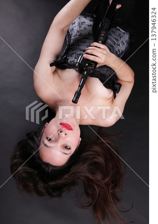 Girl holding Rifle on black background Girl holding Rifle on black background 137946324