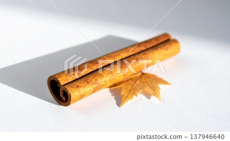 Aromatic Cinnamon Stick with Leaf on White Surface in Soft Lighting Studio Shot 137946640