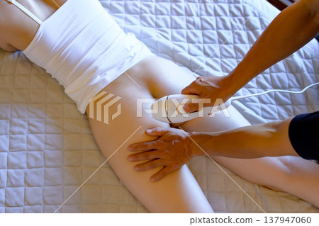 女性在伴侶(男友、丈夫)的幫助下進行 VIO 脫毛,她們面朝下躺著;使用家用除毛設備;修剪。 女性在伴侶(男友、丈夫)的幫助下進行 VIO 脫毛,她們面朝下躺著;使用家用除毛設備;修剪。 137947060