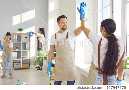 Cleaner Staff Giving High Five While Cleaning A Home Or Office Cleaner Staff Giving High Five While Cleaning A Home Or Office 137947376
