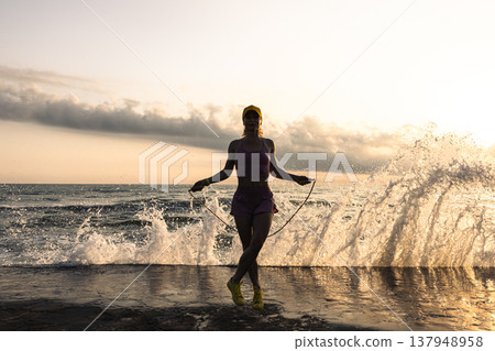 Fit woman jumping rope at the beach during summer vacation 137948958