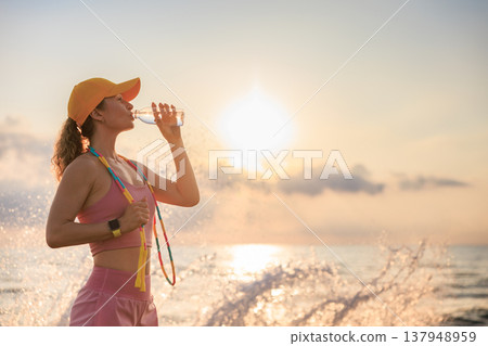 Fit woman jumping rope at the beach during summer vacation 137948959