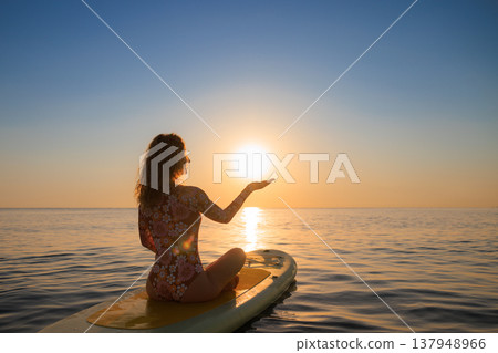Young woman walking on sup board by the sea during summer vacation Young woman walking on sup board by the sea during summer vacation 137948966
