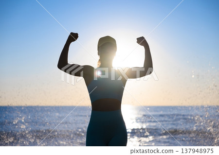 Fit young woman posing at the beach against sunrise during the summer vacation 137948975