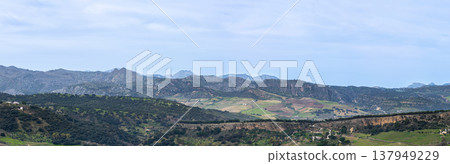 Panoramic view of surrounding landscapes and mountains from scenic elevated viewpoint in Ronda, Spain. Panoramic view of surrounding landscapes and mountains from scenic elevated viewpoint in Ronda, Spain. 137949229