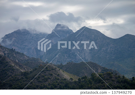Scenic view of surrounding mountains and picturesque village from a hiking trail along an old irrigation ditch in Frigiliana, Spain. 137949270