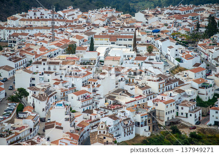 Scenic view of surrounding mountains and picturesque village from a hiking trail along an old irrigation ditch in Frigiliana, Spain. Scenic view of surrounding mountains and picturesque village from a hiking trail along an old irrigation ditch in Frigiliana, Spain. 137949271