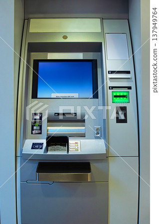A full front view of an ATM machine in a banking lobby showing all the input and output components. A full front view of an ATM machine in a banking lobby showing all the input and output components. 137949764