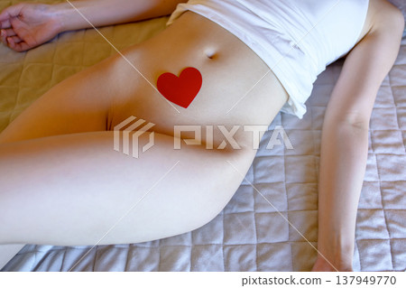 A heart-shaped object on a woman's abdomen; symbolizing menstruation, sexually transmitted diseases, and women's specific concerns. A heart-shaped object on a woman's abdomen; symbolizing menstruation, sexually transmitted diseases, and women's specific concerns. 137949770