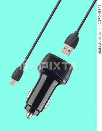 power adapter for the phone from the cigarette lighter, on a blue background power adapter for the phone from the cigarette lighter, on a blue background 137949841