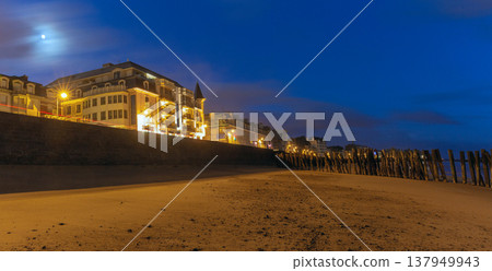 Wooden breakwaters and illuminated beachfront at night in Saint Malo France 137949943