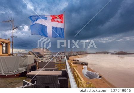 Breton flag over Saint Malo beach promenade and stormy coastline in Brittany France Breton flag over Saint Malo beach promenade and stormy coastline in Brittany France 137949946