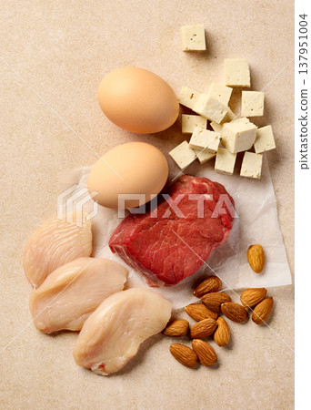 High protein foods with chicken, beef, eggs, cheese and almonds on light background, top view High protein foods with chicken, beef, eggs, cheese and almonds on light background, top view 137951004