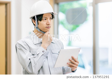 A young man wearing work clothes 137951291