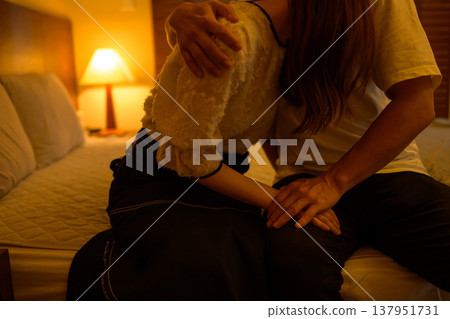 A couple sitting on the bed and hugging Japanese Asian A couple sitting on the bed and hugging Japanese Asian 137951731