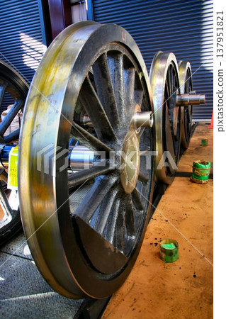 The driving wheels of the steam locomotive 'C11-123' undergoing disassembly and maintenance in the maintenance shed. The driving wheels of the steam locomotive 'C11-123' undergoing disassembly and maintenance in the maintenance shed. 137951821