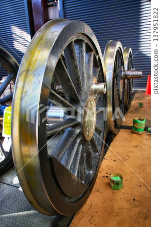 The driving wheels of the steam locomotive 'C11-123' undergoing disassembly and maintenance in the maintenance shed. The driving wheels of the steam locomotive 'C11-123' undergoing disassembly and maintenance in the maintenance shed. 137951822