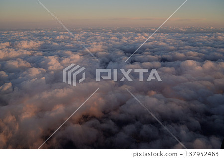 從高空俯瞰，夕陽灑在雲層上，構成了一個壯麗的天空景象。 137952463