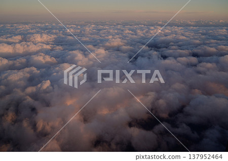 Clouds bathed in the sunset, as seen from above: a skyscape. Clouds bathed in the sunset, as seen from above: a skyscape. 137952464