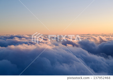 Clouds bathed in the sunset, as seen from above: a skyscape. 137952468