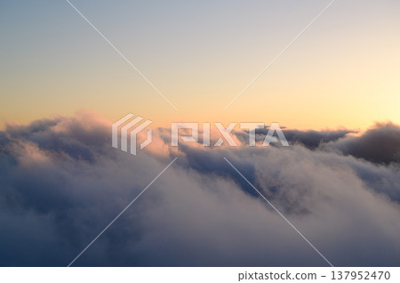 Clouds bathed in the sunset, as seen from above: a skyscape. 137952470