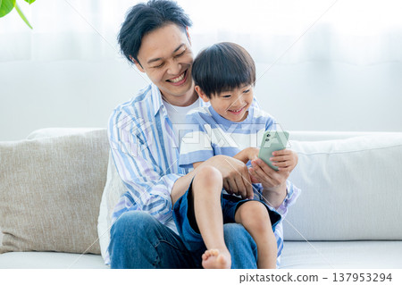 看著智能手機的年輕家庭 137953294