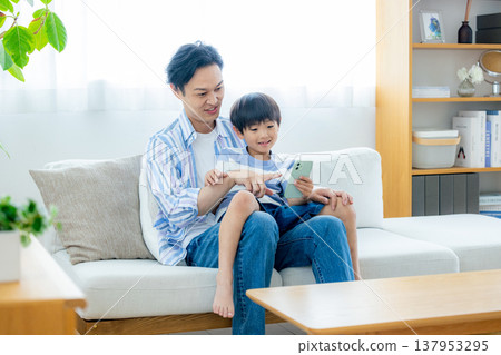 看著智能手機的年輕家庭 137953295