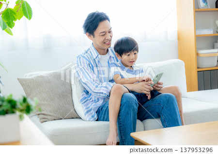 Young family looking at a smartphone Young family looking at a smartphone 137953296