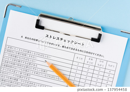 A stress check sheet and pencil in a binder against a light blue background. 137954458
