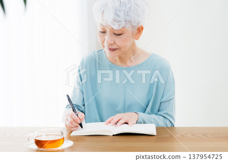 Senior women writing end-of-life notebooks 137954725