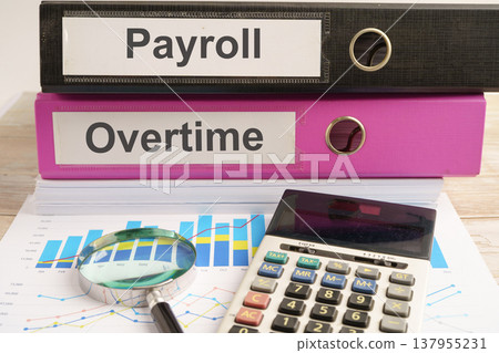Payroll Overtime. binder with graph and calculator in business office. 137955231