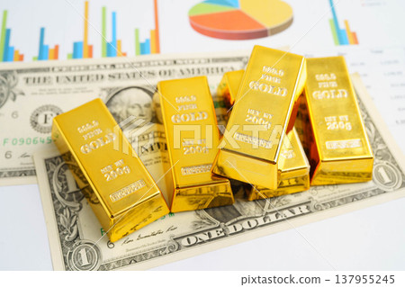 Gold bars on graph paper, finance trading investment business currency. Gold bars on graph paper, finance trading investment business currency. 137955245