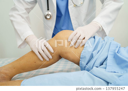 Doctor checking Asian elderly woman patient with scar knee replacement surgery in hospital. Doctor checking Asian elderly woman patient with scar knee replacement surgery in hospital. 137955247