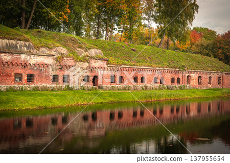 Old brick wall of Fort 5 King Frederick William III by moat in Kaliningrad. Russia Old brick wall of Fort 5 King Frederick William III by moat in Kaliningrad. Russia 137955654
