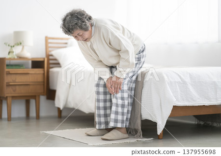 A woman in her 80s holding her knees 137955698