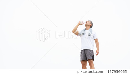 一名男子正在用塑膠瓶喝水。 137956065