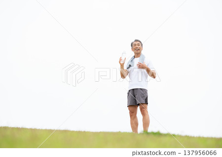 一名男子正在用塑膠瓶喝水。 137956066