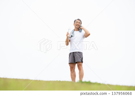 一名男子正在用塑膠瓶喝水。 137956068