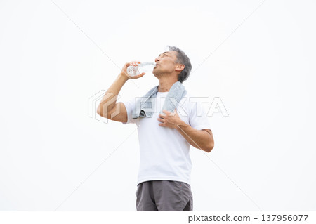 一名男子正在用塑膠瓶喝水。 137956077