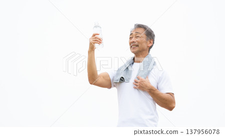 A man drinking water from a plastic bottle. 137956078