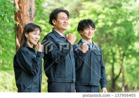 Male and female workers in forestry and civil engineering work clothes posing in the forest Male and female workers in forestry and civil engineering work clothes posing in the forest 137956405