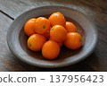 Kumquats served on a black plate 137956423